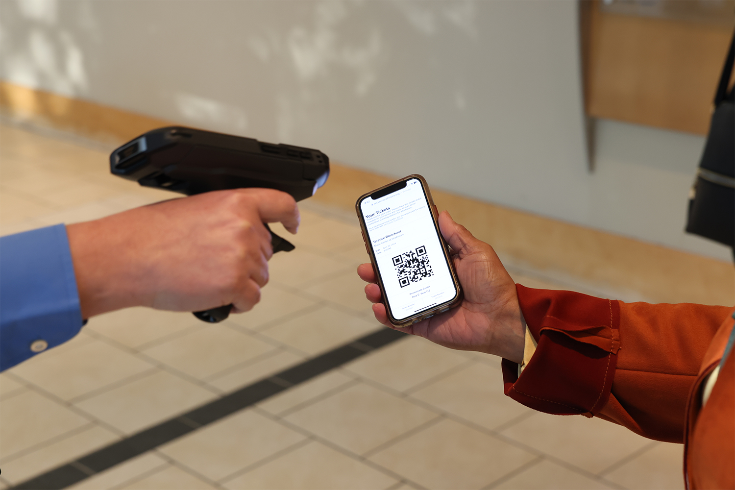 Patron Holding Up Their Mobile Ticket To Be Scanned