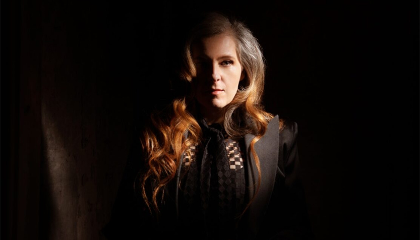 Neko Case In Black Clothing Partially Obscured By Shadow