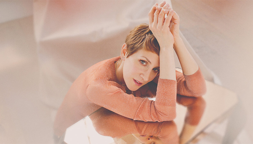 Stacey Kent In A Peach Sweater With Hands Near Face