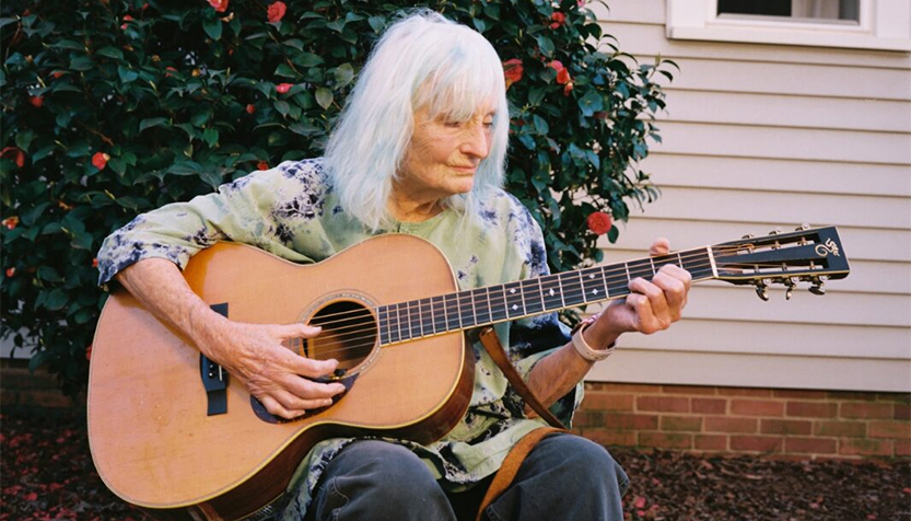 Alice Gerrard Sitting Outside With Her Guitar