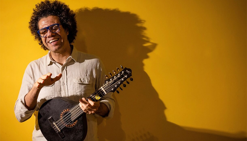 Hamilton De Holanda With Instrument On Yellow Background