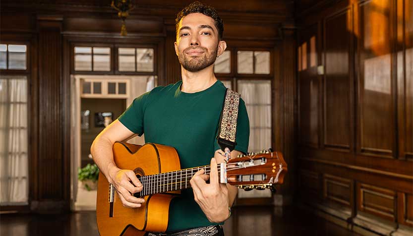 Juan Manu In A Green Tshirt Playing The Guitar