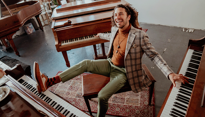 Emmet Cohen In A Plaid Suit Surrounded By Pianos