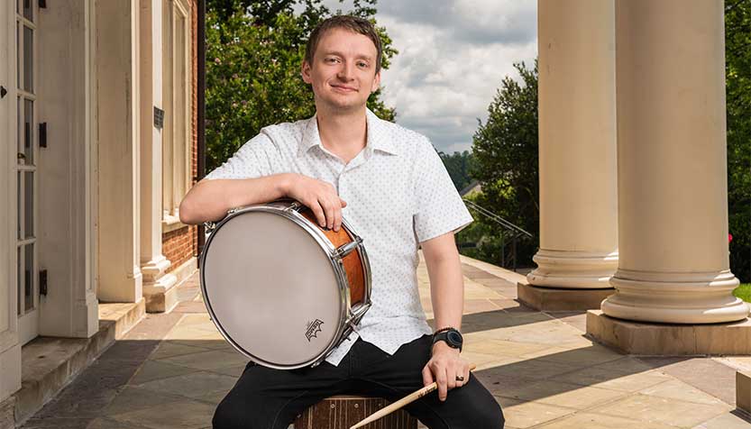 Michael Mcsweeney In A White Shirt Holding A Small Drum