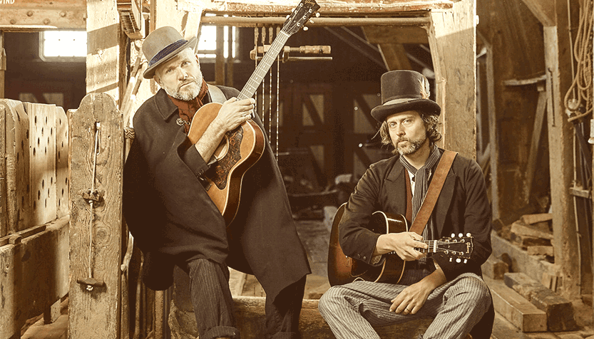 Sons Of Town Hall Holding Their Instruments In A Barn