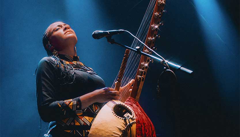 Sona Jobarteh With Eyes Half Closed Performing In The Spotlight