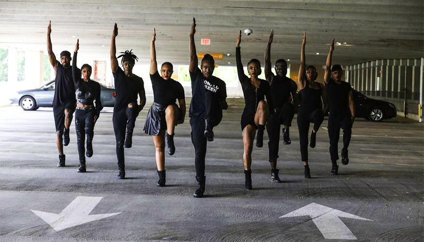 Step Afrika! stepping through a parking garage