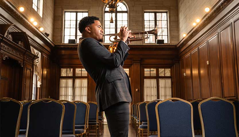 Cyrus Mackey In A Plaid Suit Blowing The Trumpet
