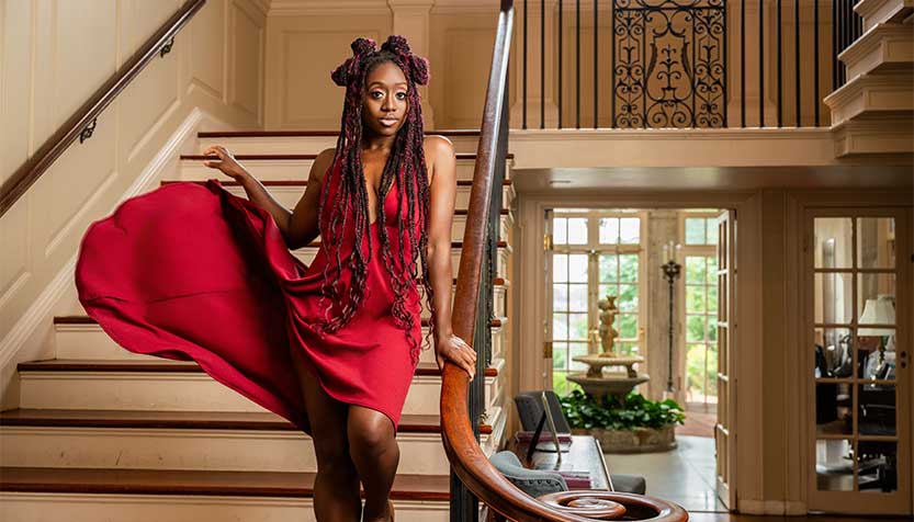 Kanysha Williams Flourishing A Red Dress Standing On The Mansion Staircase