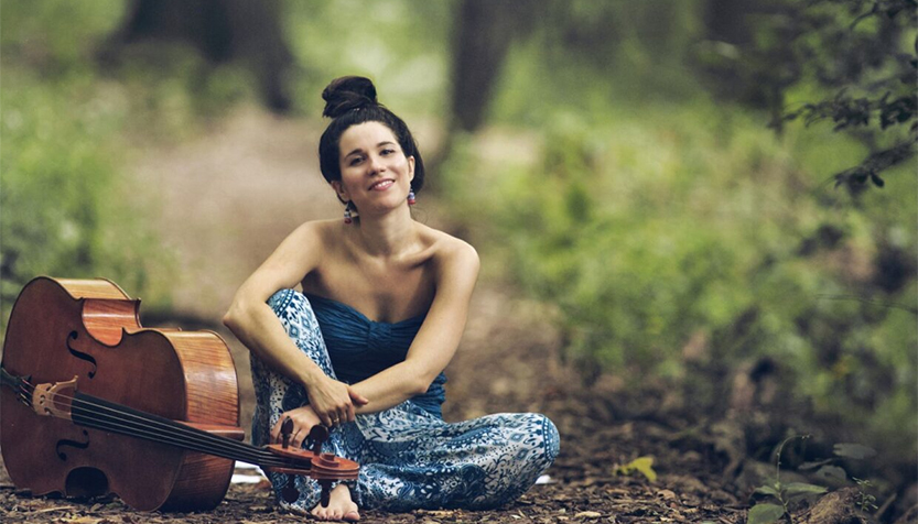 Andrea Casarrubios Sitting On The Ground In A Forest With Her Cello