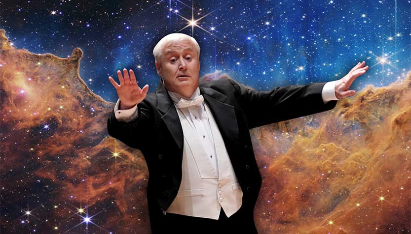 Piotr Gajewski In A Tuxedo Conducting Against A Galactic Background