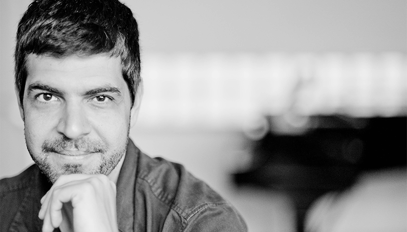 Andre Mehmari Gazing Into The Camera With One Hand To His Chin