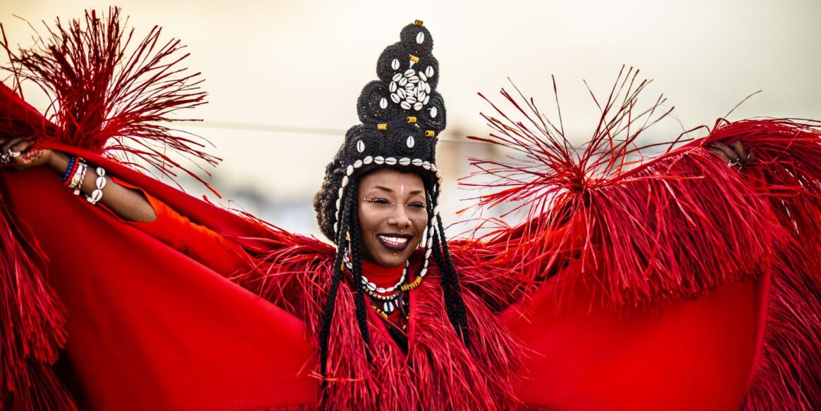 Fatoumata Diawara In Red Costume With Elaborate Braids